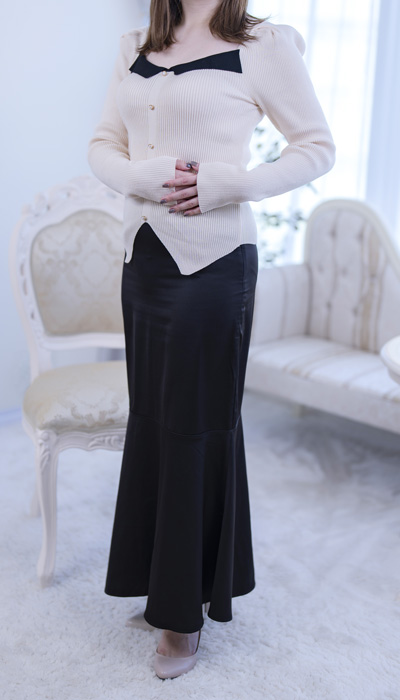 ホワイトのトップスに黒のロングスカートを合わせた、モノトーンで知的な女性会員。